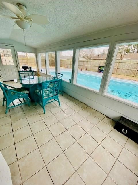 unfurnished sunroom with a wealth of natural light, lofted ceiling, and ceiling fan