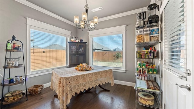 dining area with dark wood-type flooring, crown molding, baseboards, and an inviting chandelier