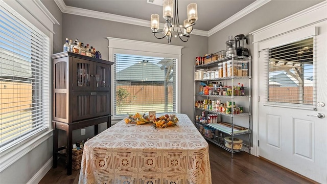 dining space featuring a notable chandelier, a healthy amount of sunlight, dark wood-style floors, and crown molding