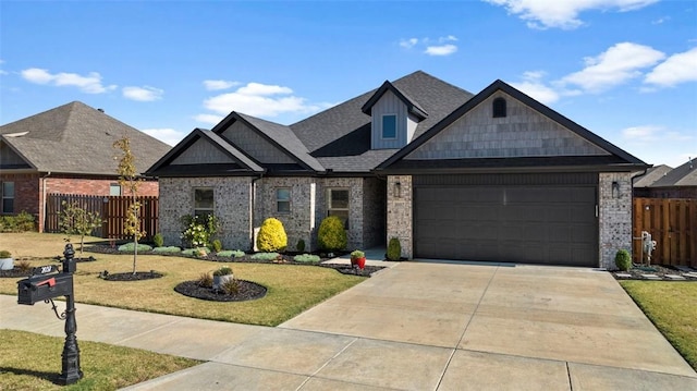 craftsman inspired home featuring brick siding, a front yard, fence, a garage, and driveway