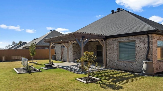 back of house featuring a lawn, roof with shingles, fence, a patio area, and brick siding