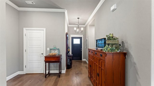 entryway featuring baseboards, visible vents, wood finished floors, and ornamental molding