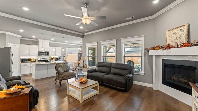 living room featuring dark wood-style flooring, a fireplace, visible vents, a ceiling fan, and baseboards