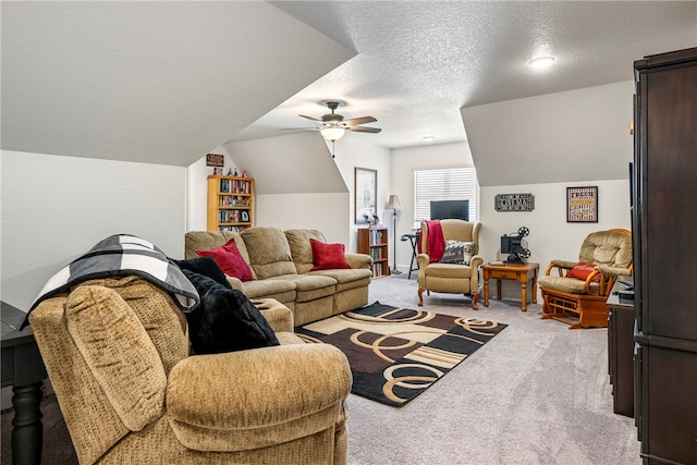 living room with ceiling fan, a textured ceiling, lofted ceiling, and light colored carpet