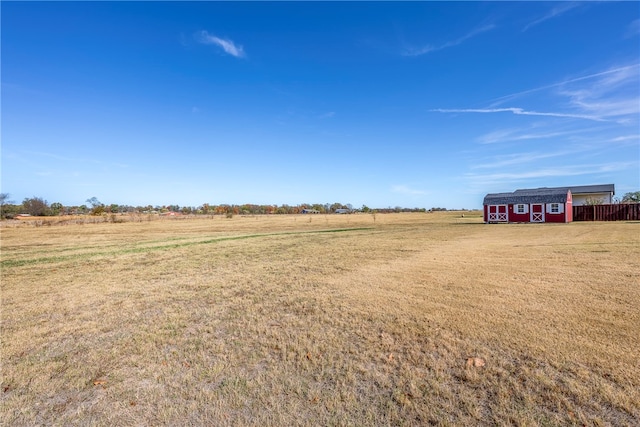 view of yard with a rural view and an outdoor structure