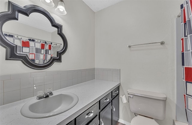 bathroom featuring vanity, toilet, and a textured ceiling