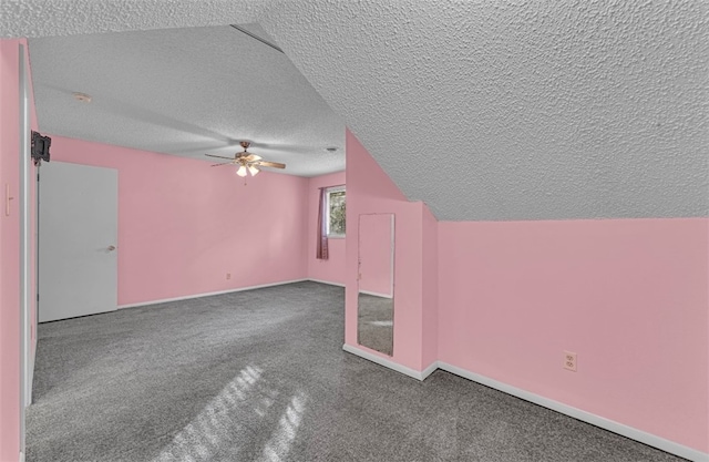 additional living space with lofted ceiling, a textured ceiling, carpet, and ceiling fan