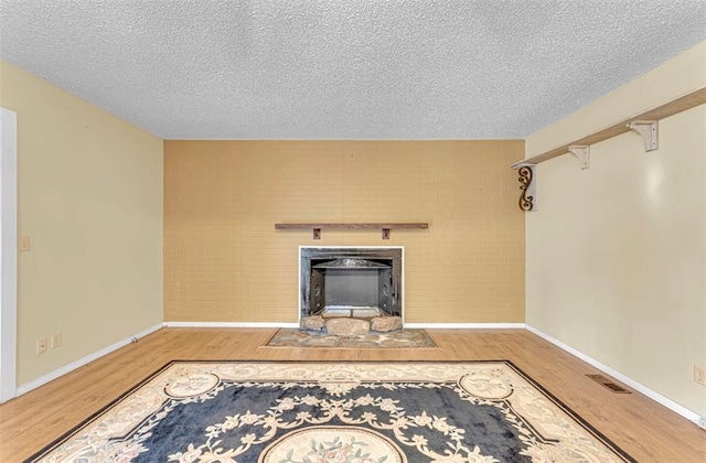 unfurnished living room with hardwood / wood-style floors and a textured ceiling