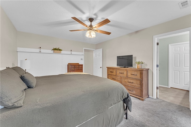 carpeted bedroom with a textured ceiling and ceiling fan