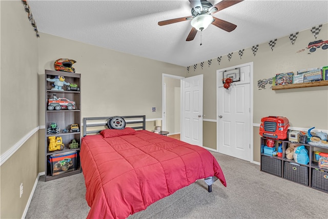 bedroom featuring ceiling fan, a textured ceiling, and carpet flooring