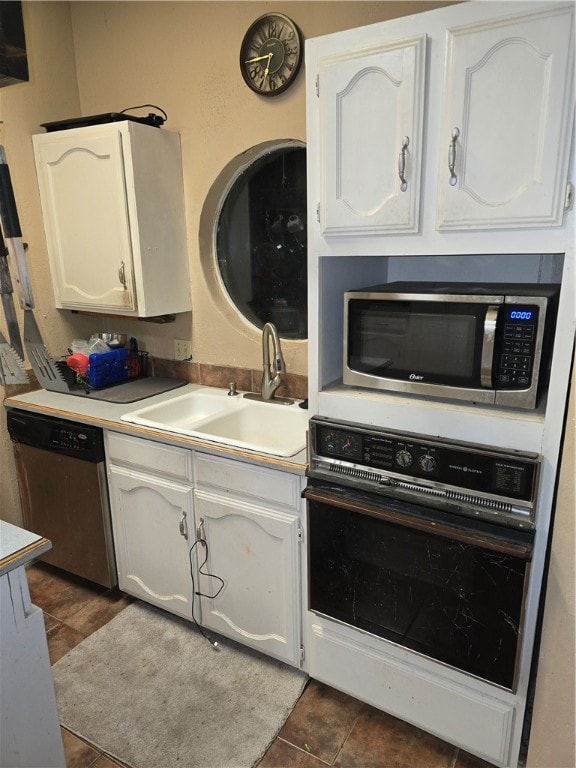 kitchen featuring white cabinets, dark tile patterned floors, sink, and appliances with stainless steel finishes