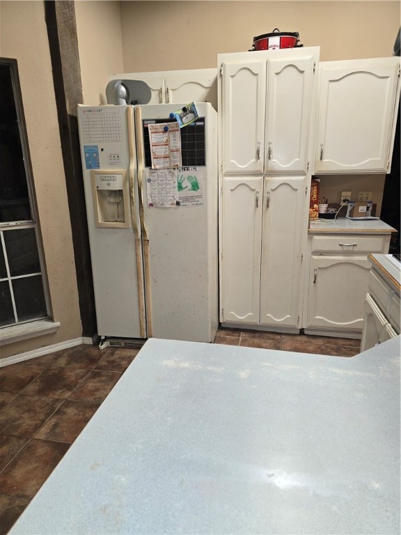 kitchen featuring white refrigerator with ice dispenser and white cabinets