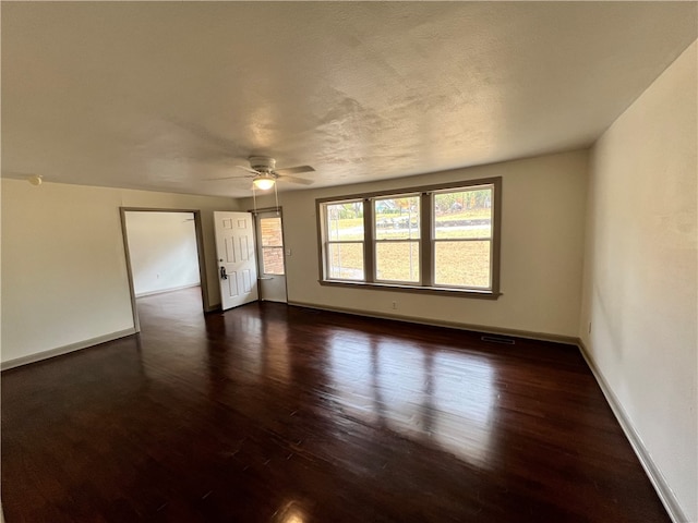 empty room with dark wood-type flooring, ceiling fan, and a textured ceiling