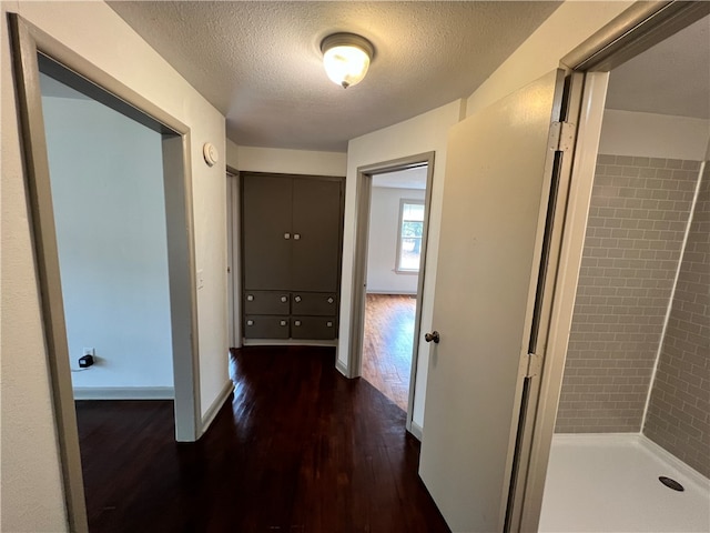 hall featuring dark hardwood / wood-style floors and a textured ceiling