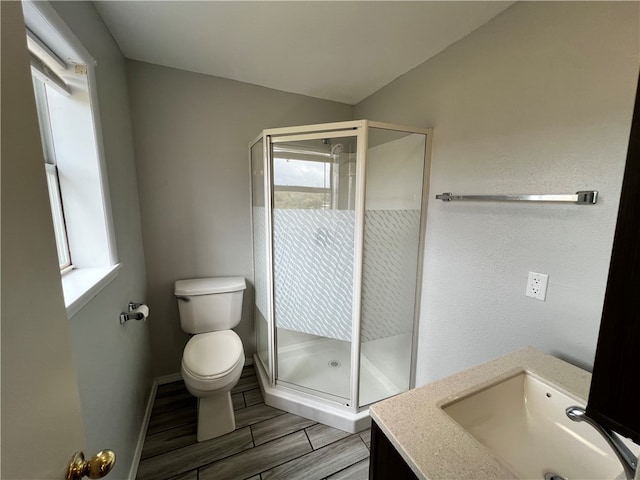 bathroom with toilet, wood-type flooring, vaulted ceiling, vanity, and walk in shower