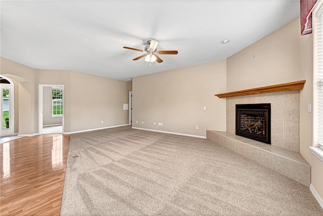 unfurnished living room with a fireplace, a ceiling fan, and baseboards