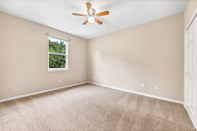 spare room featuring carpet, baseboards, and a ceiling fan