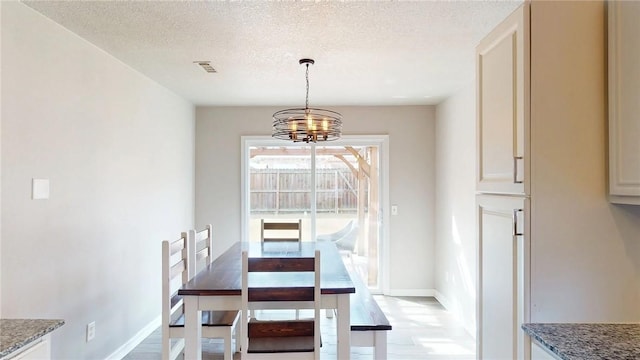 dining room with a textured ceiling and an inviting chandelier