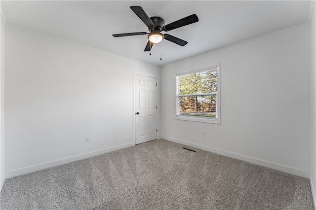 carpeted empty room featuring ceiling fan and crown molding