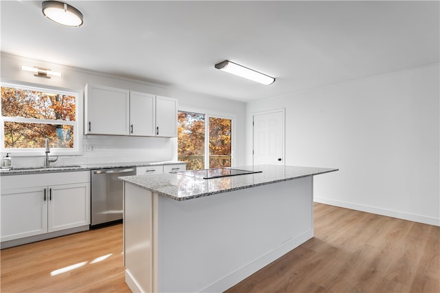 kitchen with stainless steel dishwasher, white cabinets, a healthy amount of sunlight, and a kitchen island