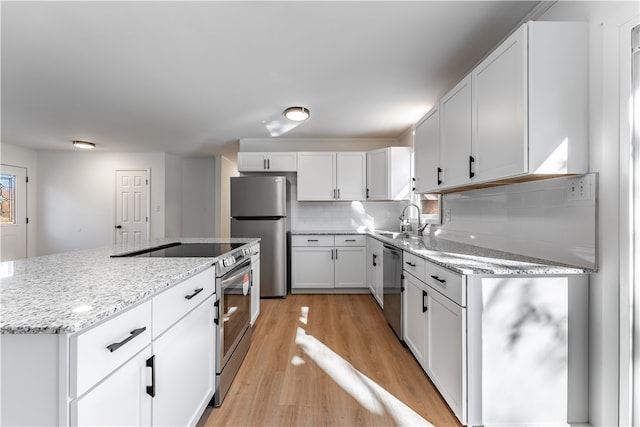 kitchen featuring white cabinetry, sink, light wood-type flooring, and appliances with stainless steel finishes