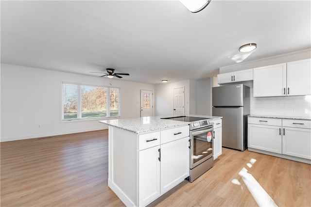 kitchen with light hardwood / wood-style flooring, a kitchen island, white cabinetry, and stainless steel appliances