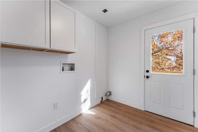 laundry room with cabinets, light hardwood / wood-style floors, and hookup for a washing machine