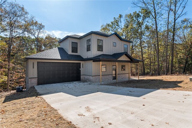 view of front of house featuring central air condition unit, a garage, and covered porch