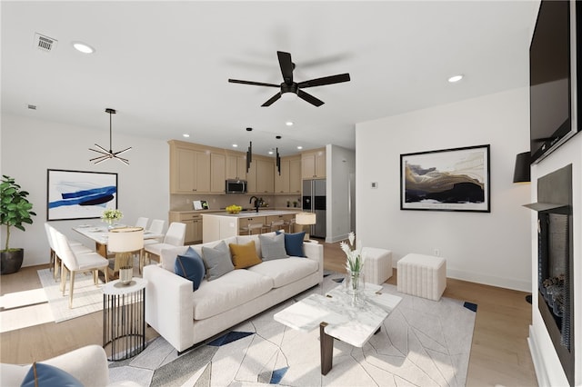 living area featuring recessed lighting, light wood-type flooring, and visible vents