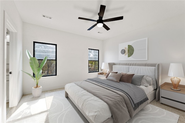 bedroom featuring ceiling fan, baseboards, visible vents, and light carpet