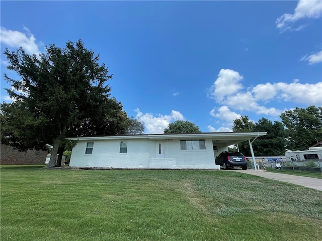 view of front of home with a carport and a front lawn