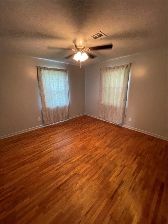 spare room featuring ceiling fan, wood-type flooring, and a textured ceiling