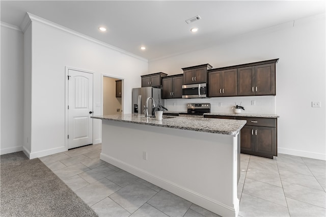 kitchen featuring dark brown cabinets, stainless steel appliances, crown molding, and an island with sink