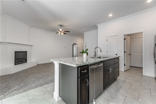 kitchen with sink, dishwasher, light colored carpet, ceiling fan, and a kitchen island with sink