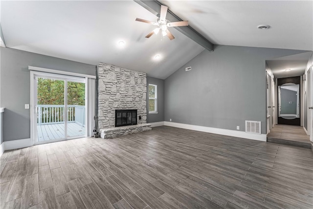 unfurnished living room featuring a stone fireplace, lofted ceiling with beams, ceiling fan, and dark hardwood / wood-style floors