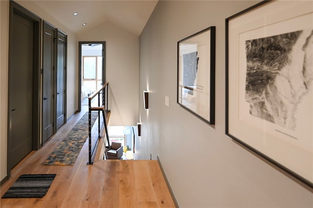 hall featuring hardwood / wood-style flooring and vaulted ceiling