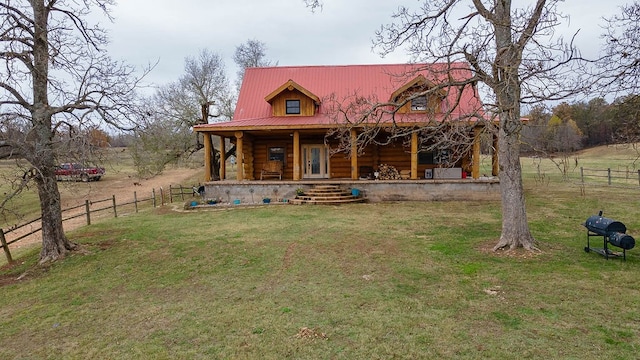 rear view of house with a porch and a yard