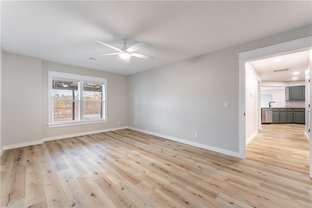 unfurnished room featuring a ceiling fan, baseboards, light wood-style flooring, and visible vents