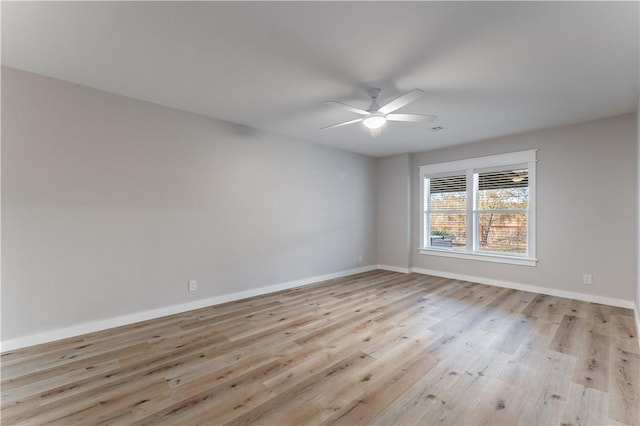 unfurnished room with baseboards, light wood-style floors, and a ceiling fan