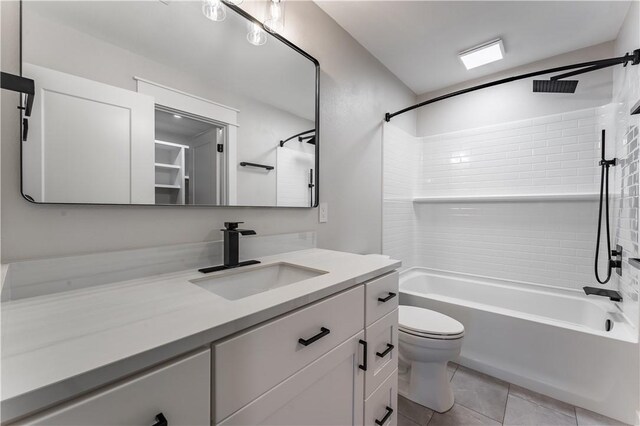 full bathroom with toilet, tiled shower / bath combo, vanity, and tile patterned flooring