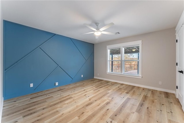 unfurnished room featuring baseboards, light wood-type flooring, visible vents, and a ceiling fan