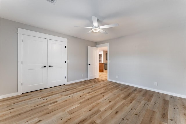 unfurnished bedroom with baseboards, a closet, light wood-style floors, and ceiling fan