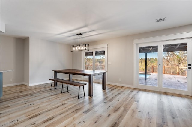 dining space with baseboards, visible vents, and light wood-style floors
