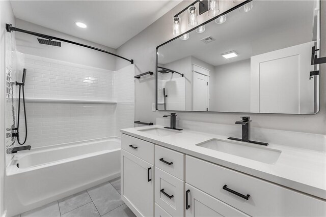 bathroom featuring tile patterned flooring, vanity, and tiled shower / bath