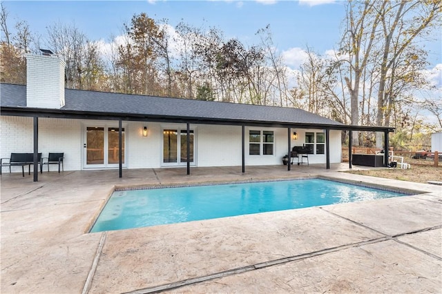 10729 Anzac Dr, Lowell, AR 72745 - back of property featuring a patio, brick siding, a chimney, an outdoor pool, and a hot tub