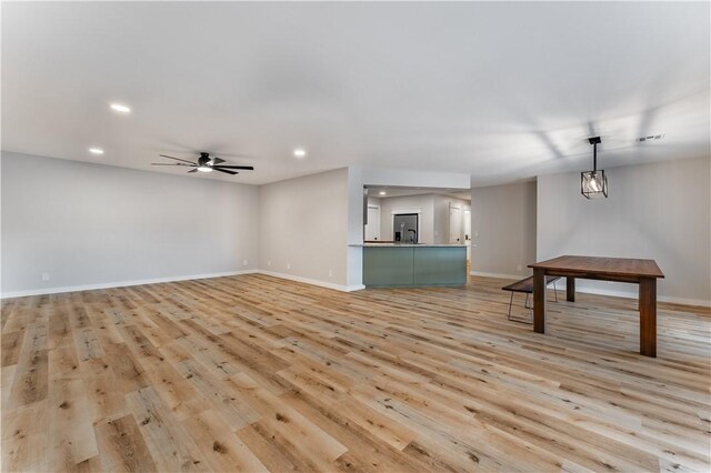 unfurnished living room featuring ceiling fan and light wood-type flooring