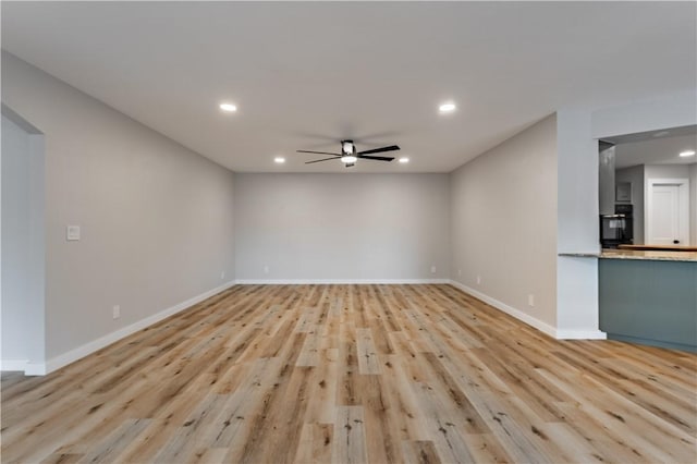 unfurnished living room with a ceiling fan, baseboards, light wood finished floors, and recessed lighting