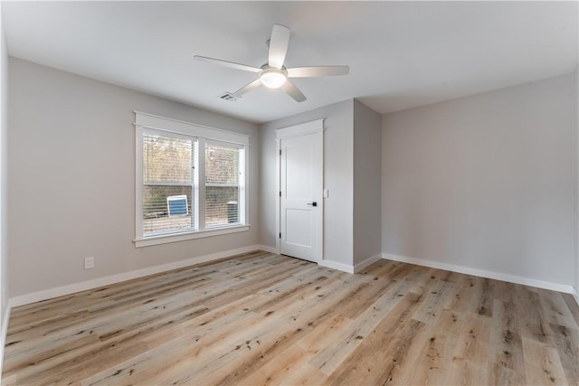 unfurnished bedroom featuring baseboards, visible vents, a closet, ceiling fan, and wood finished floors