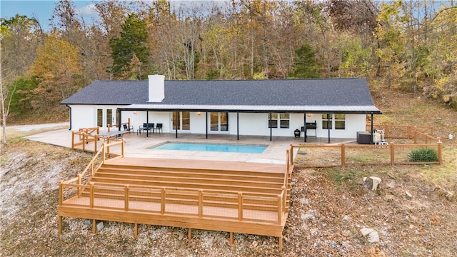 back of house with central air condition unit and a swimming pool side deck