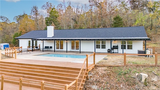 rear view of property with a patio, central air condition unit, and a pool side deck